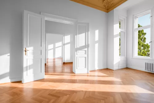 A painter using a roller to paint a large exterior wall.